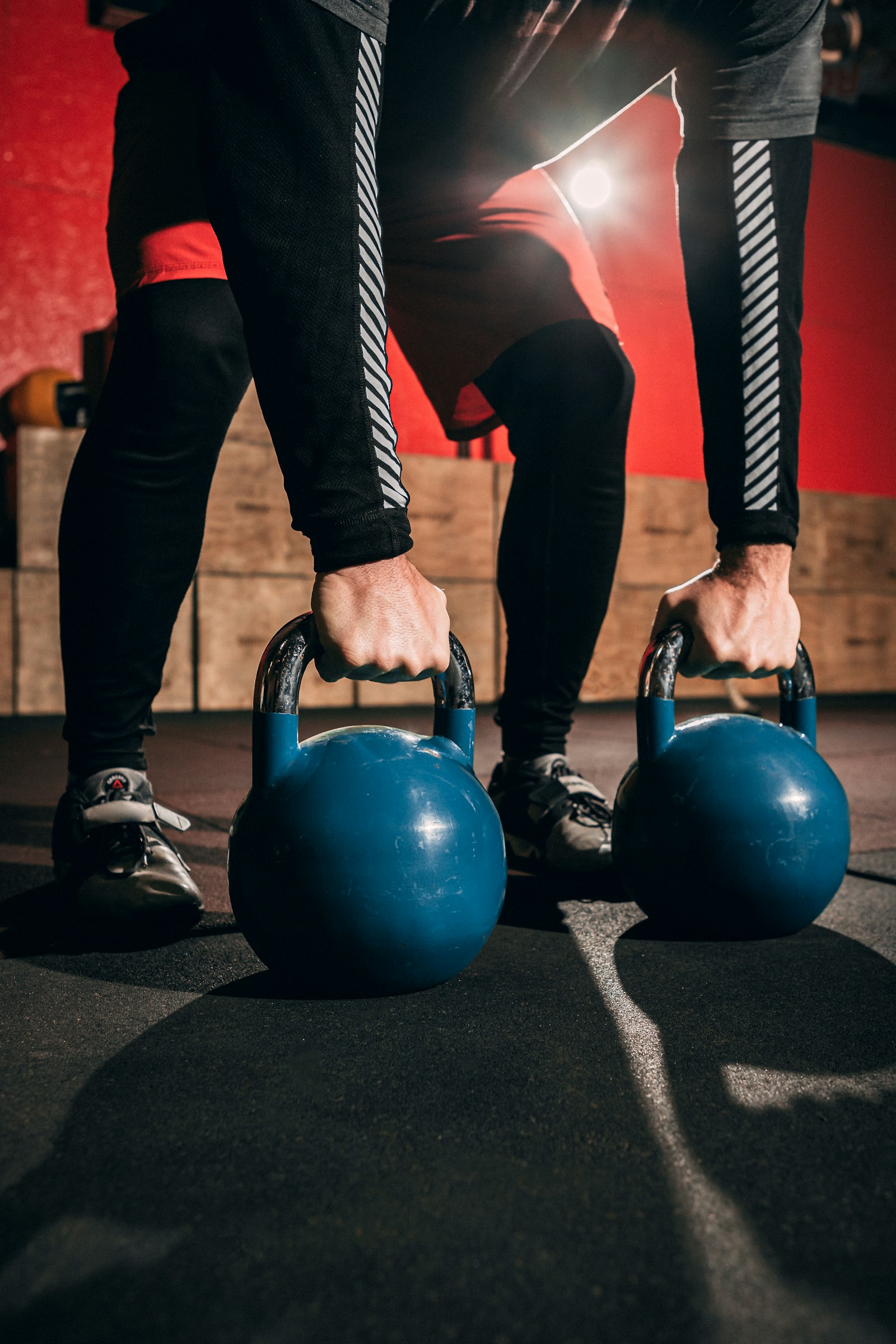 İki mavi kettlebell tutan eller
